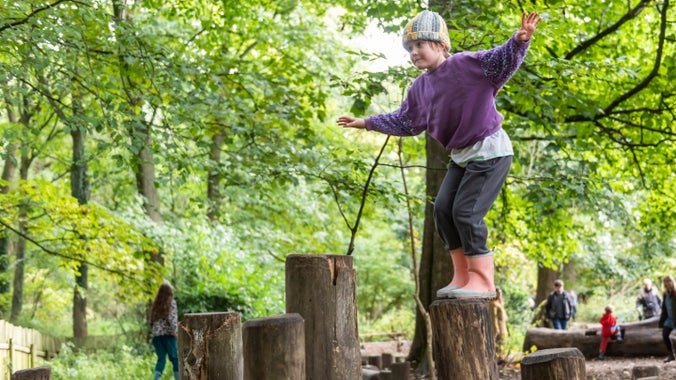 Families exploring Wolf’s Den natural play area at Erddig